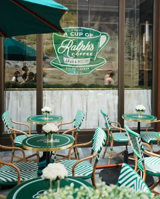 Green striped bistro chairs on the sidewalk outside Ralph's Coffee