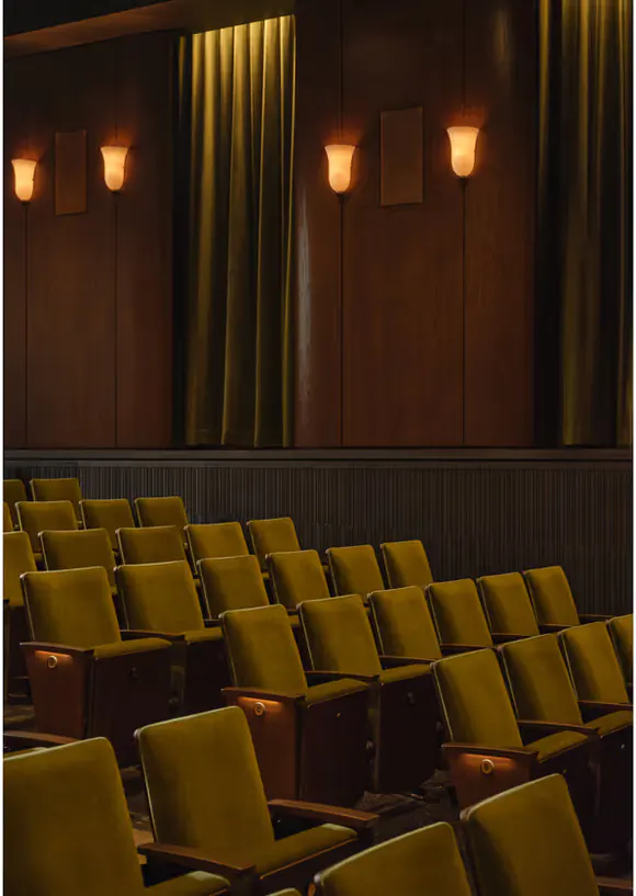 Rows of olive velvet seats facing the curtained stage inside Cherry Lane Theatre